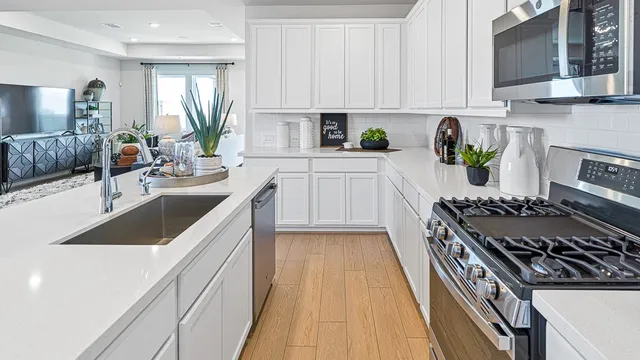 a kitchen with a sink stove top oven and microwave