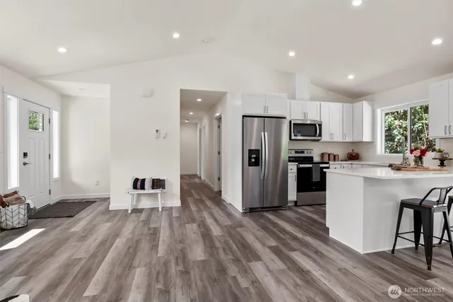 a kitchen with a refrigerator and a stove top oven