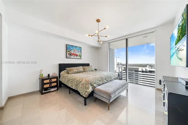 a bedroom with a bed and a chandelier