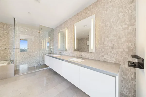 a large bathroom with a tub sink and mirror