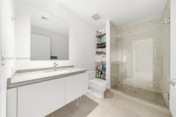 a bathroom with a sink a toilet and shower
