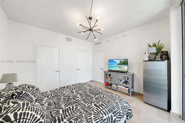 a bedroom with a bed and a flat screen tv