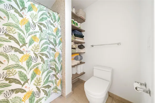 a white toilet sitting next to a shower curtain