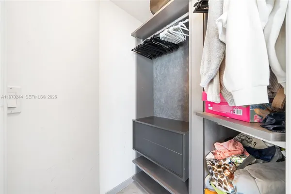 a view of walk in closet with clothes and shoes