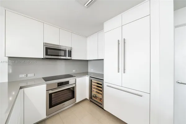 a kitchen with stainless steel appliances white cabinets and a refrigerator