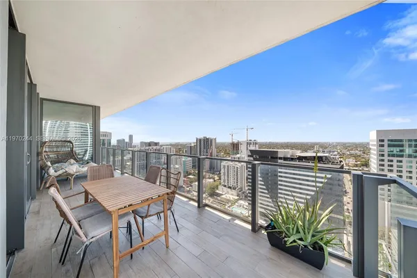 a balcony with wooden floor table and chairs