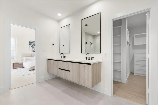 a bathroom with a double vanity sink mirror and shower