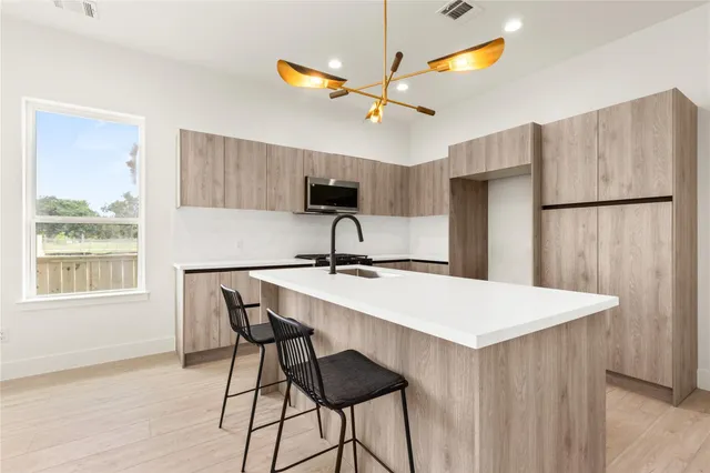a kitchen with a table chairs a refrigerator and a window