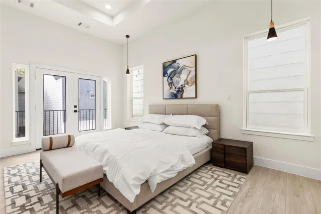 a bedroom with a bed painting on wall and a large window