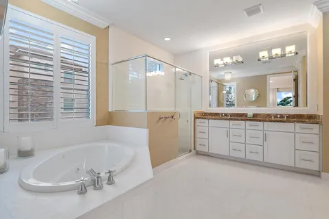 a spacious bathroom with a tub sink and mirror