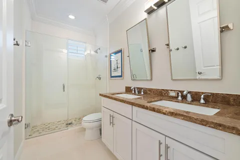 a bathroom with a granite countertop sink a toilet and a mirror