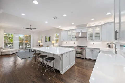 a large kitchen with kitchen island a stove a sink a dining table and chairs