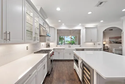 a kitchen with a sink a counter top space stainless steel appliances and cabinets