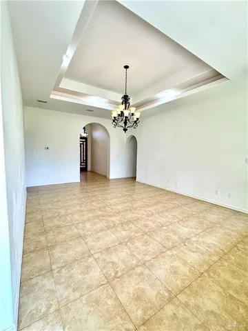 a view of a livingroom with a chandelier windows and chandelier fan