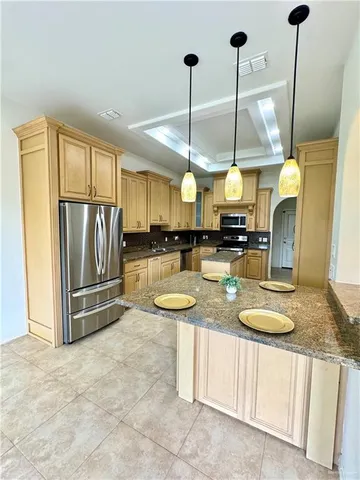a kitchen with stainless steel appliances granite countertop a sink a stove and a refrigerator