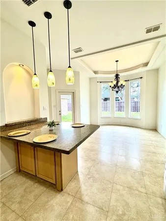 a view of a kitchen with kitchen island stainless steel appliances a sink a counter top space and living room view