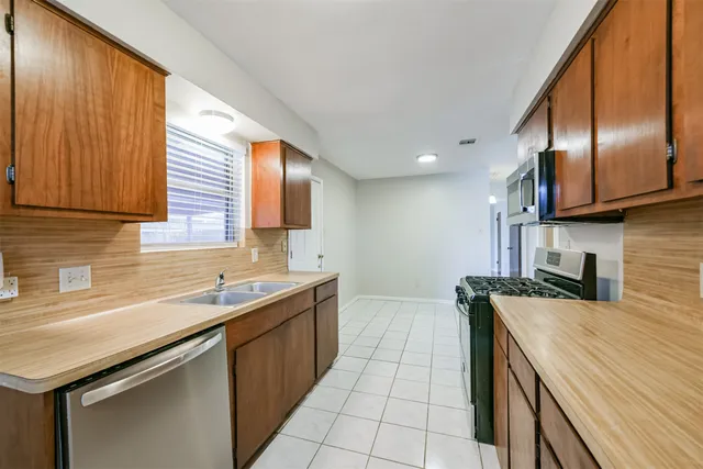 a kitchen with stainless steel appliances granite countertop a sink stove and cabinets