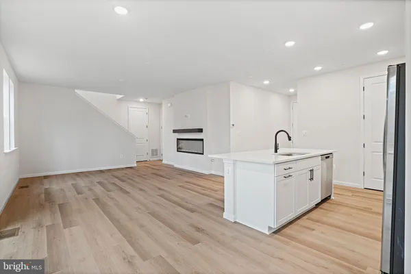 a large white kitchen with stainless steel appliances