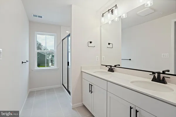 a bathroom with a sink and mirror with shower