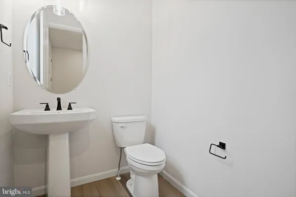 a bathroom with a toilet a sink and mirror