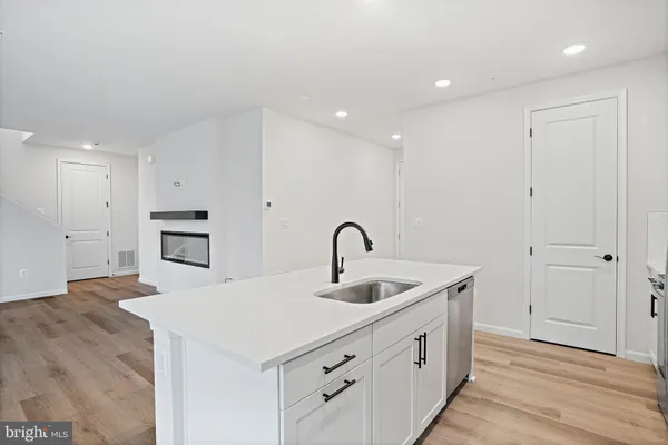 a kitchen with sink cabinets and wooden floor