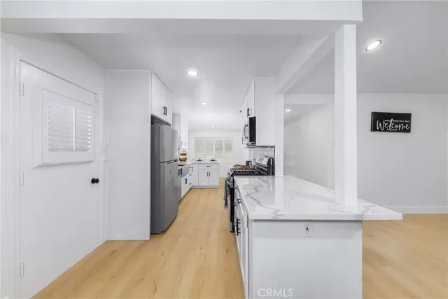 a kitchen with white cabinets and refrigerator