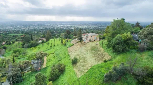 an aerial view of residential houses with outdoor space and trees