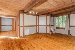 an empty room with wooden floor and a floor to ceiling window