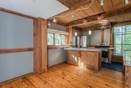 a view of a kitchen with a sink and dishwasher with wooden floor