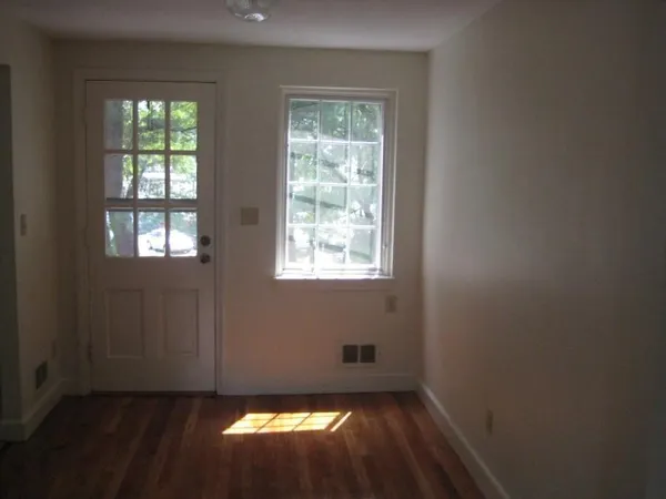 a view of an empty room with wooden floor