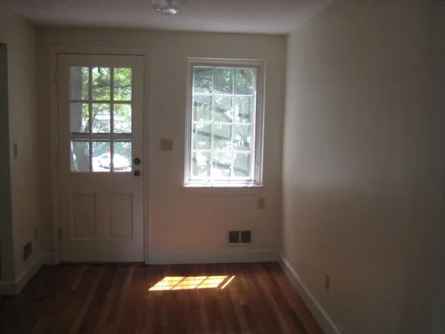 a view of an empty room with wooden floor