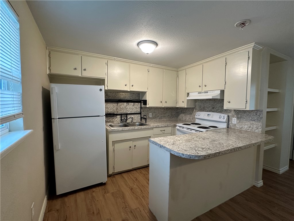 10837 Leopard Street, Unit A Corpus Christi, TX 78410 - Photo 2 of 7 a kitchen with a refrigerator sink and cabinets