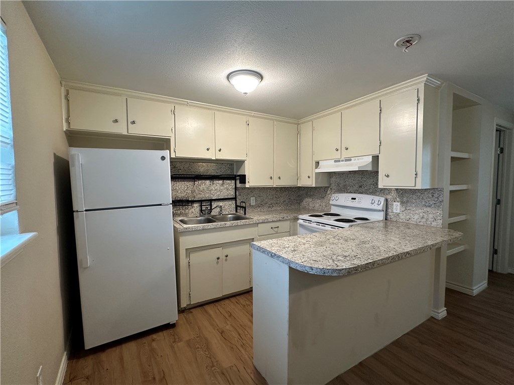 10837 Leopard Street, Unit A Corpus Christi, TX 78410 - Photo 3 of 7 a kitchen with stainless steel appliances granite countertop white refrigerator a stove a sink and a refrigerator
