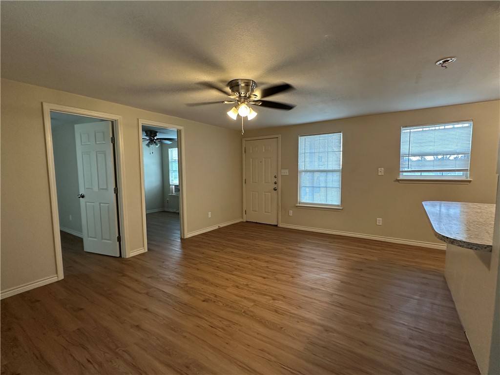 10837 Leopard Street, Unit A Corpus Christi, TX 78410 - Photo 4 of 7 a view of an empty room with window and wooden floor