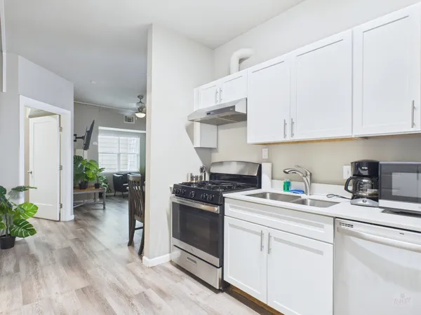 a kitchen with stainless steel appliances white cabinets and a stove top oven