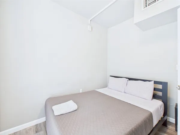 a bedroom with a bed and a white wall