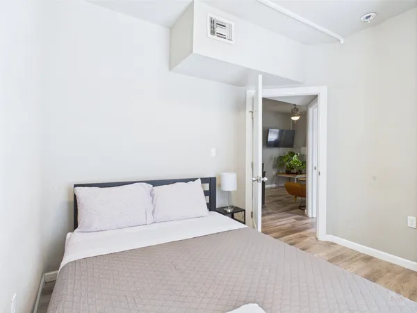 a bedroom with a bed and a potted plant