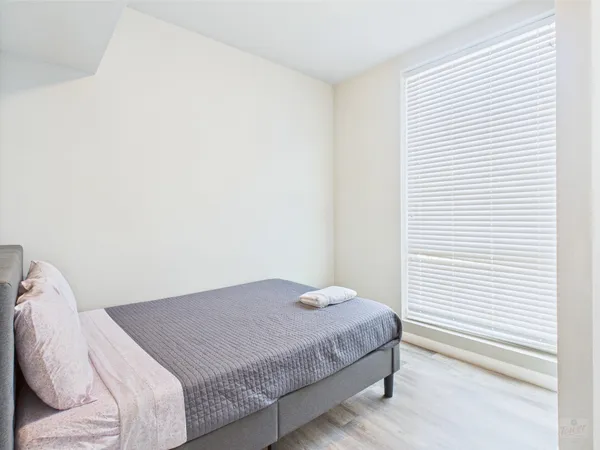 a bedroom with a bed and a white wall