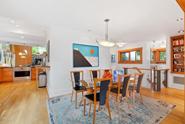 a view of a dining room and livingroom with furniture wooden floor a chandelier