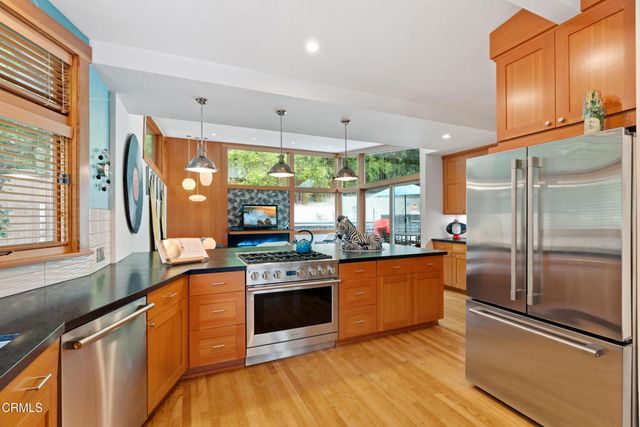 a kitchen with stainless steel appliances granite countertop a sink a stove and a refrigerator
