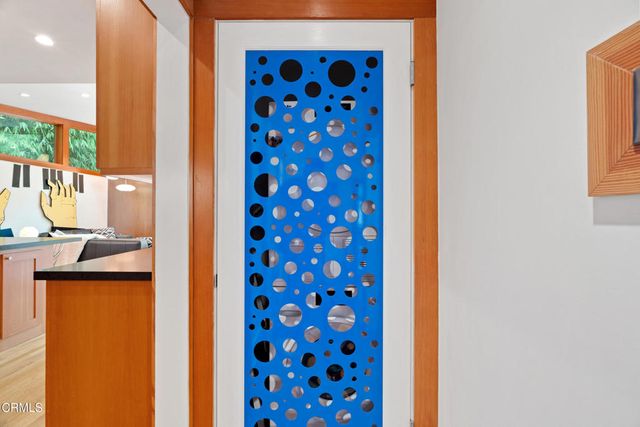 a view of a patio with table and chairs under an umbrella with large trees