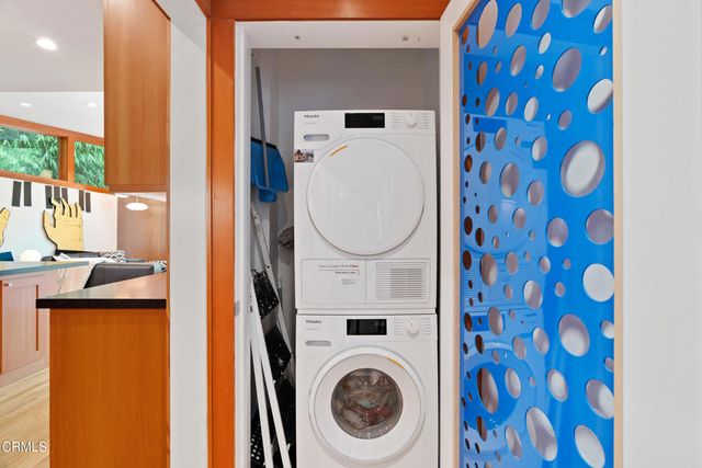 a view of a patio with table and chairs potted plants and a large tree