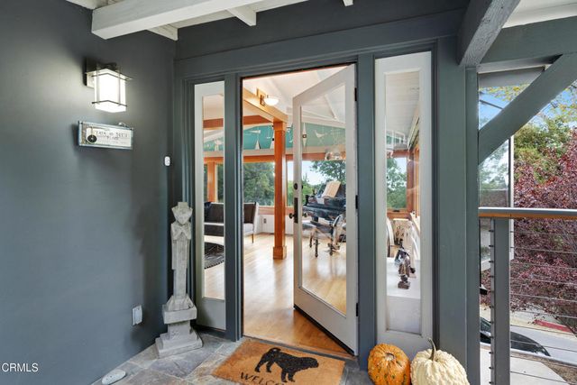 a living room with furniture a floor to ceiling window and wooden floor