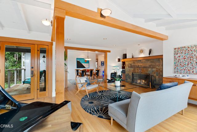 a living room with furniture a fireplace and a floor to ceiling window
