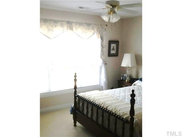1609 Stannard Trail Raleigh, NC 27612 - Photo 16 of 25 a bedroom with a bed and a chandelier