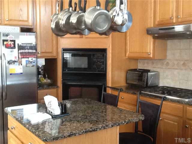 1609 Stannard Trail Raleigh, NC 27612 - Photo 5 of 25 a kitchen with stainless steel appliances granite countertop a stove a sink and a microwave
