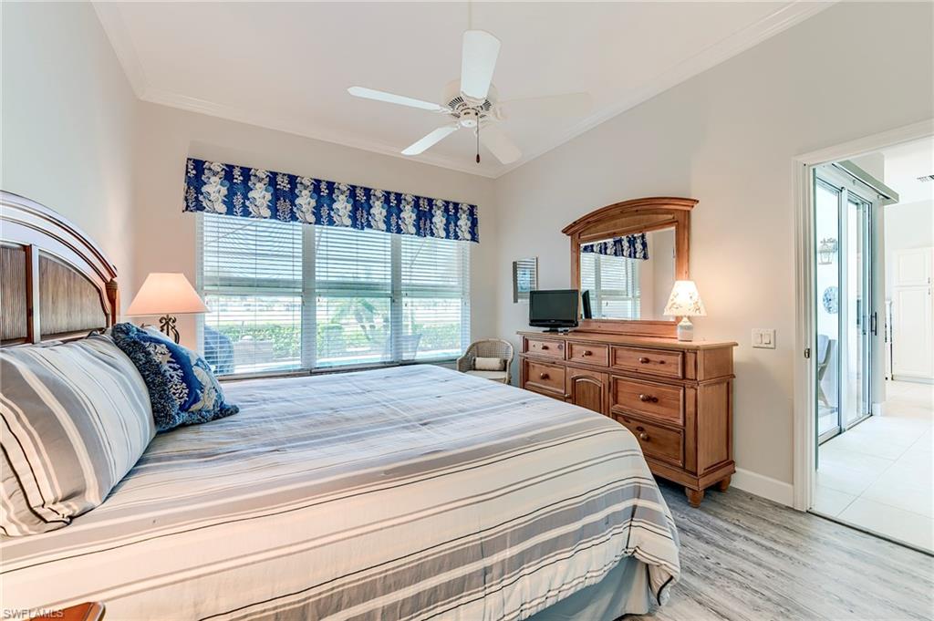 9049 Spring Run Boulevard Estero, FL 34135 - Photo 16 of 36 a bedroom with a large bed and a large window