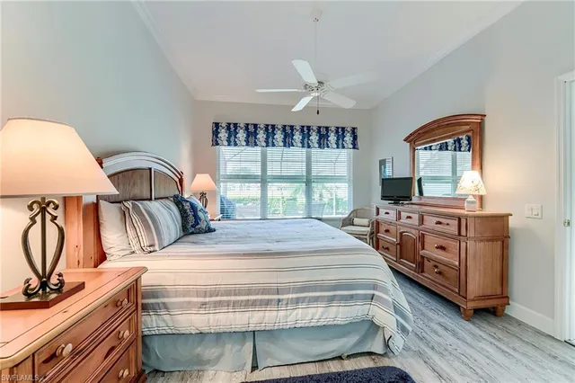 a bedroom with a bed a dresser next to a window