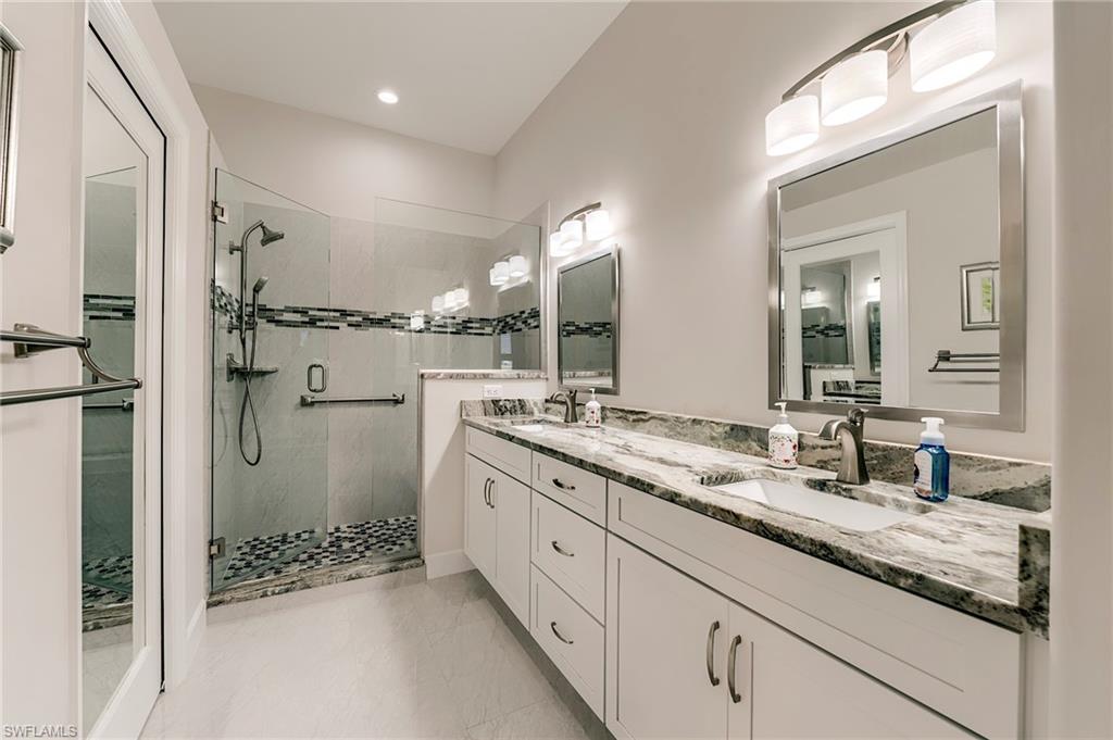 9049 Spring Run Boulevard Estero, FL 34135 - Photo 19 of 36 a bathroom with a granite countertop sink mirror and double