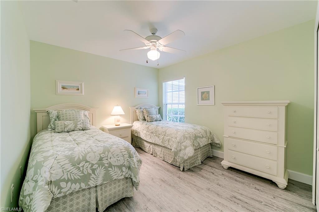 9049 Spring Run Boulevard Estero, FL 34135 - Photo 21 of 36 a bedroom with two beds and a ceiling fan